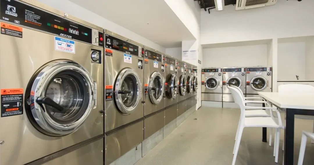 UniLodge, laundry room with washing machines & dryers with large central folding table