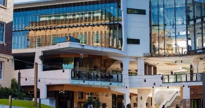 The Mayne Medical School building is reflected in the sleek windows of the UQ Oral Health Centre